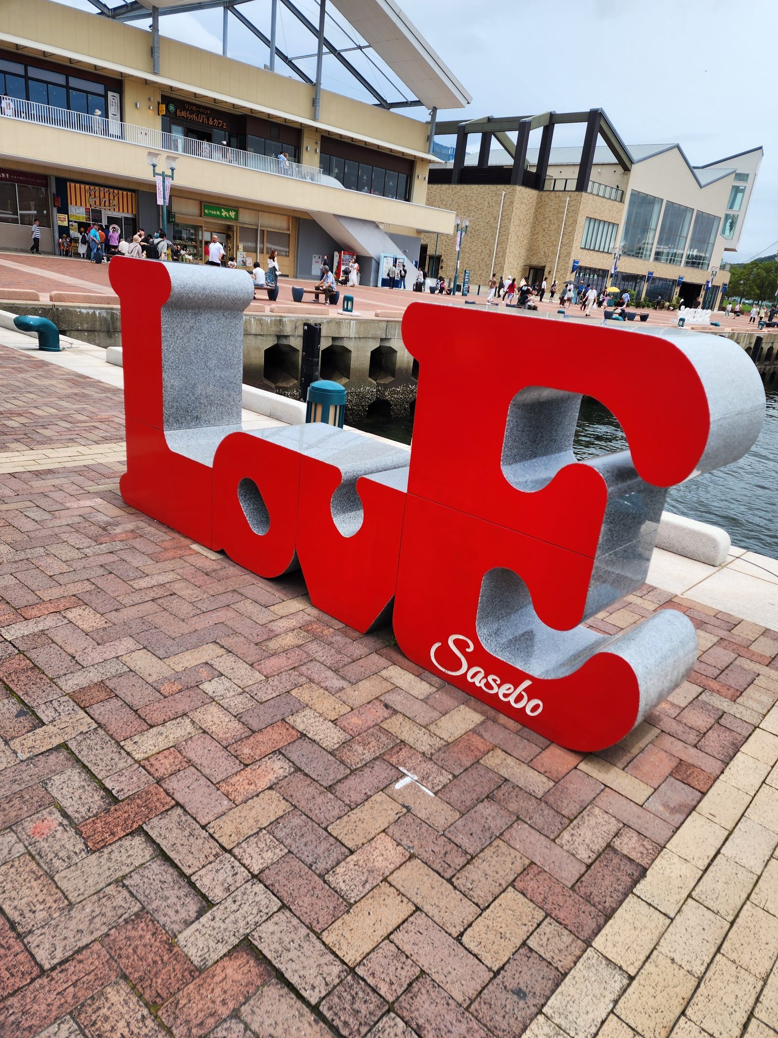 사세보 항구 광장의 빨간 LOVE Sasebo 조형물과 뒤편 물가