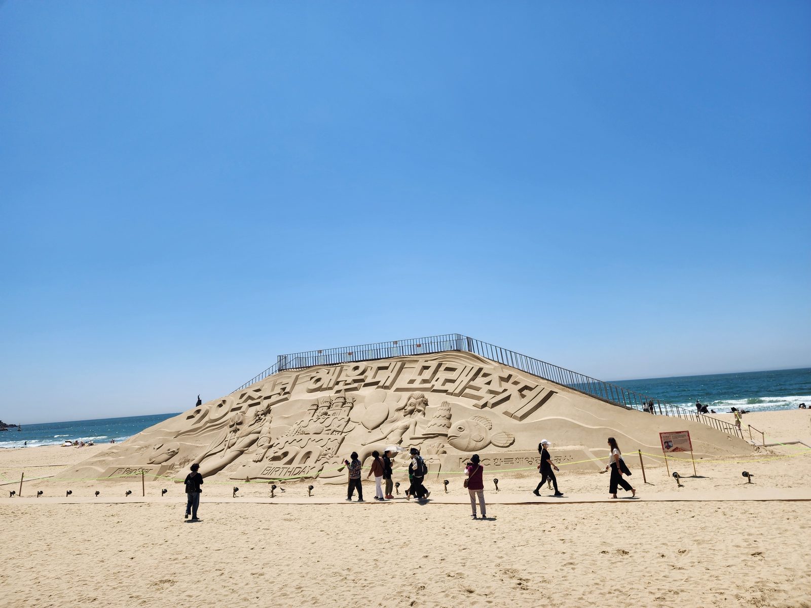 해운대해수욕장의 대형 모래 조각과 푸른 하늘, 뒤쪽의 바다