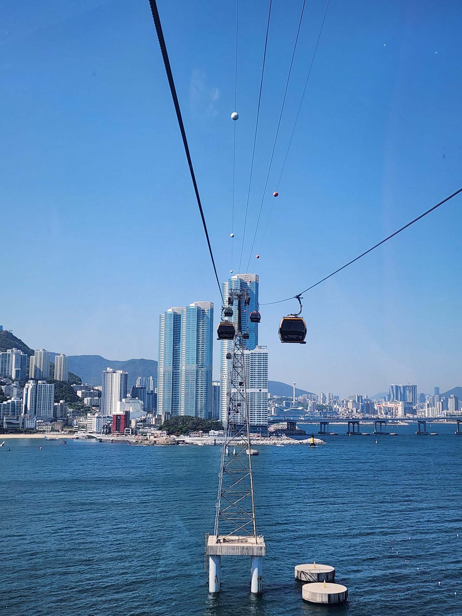 돌아오는 송도해상케이블카에서 본 바다 위 객실과 해안의 건물