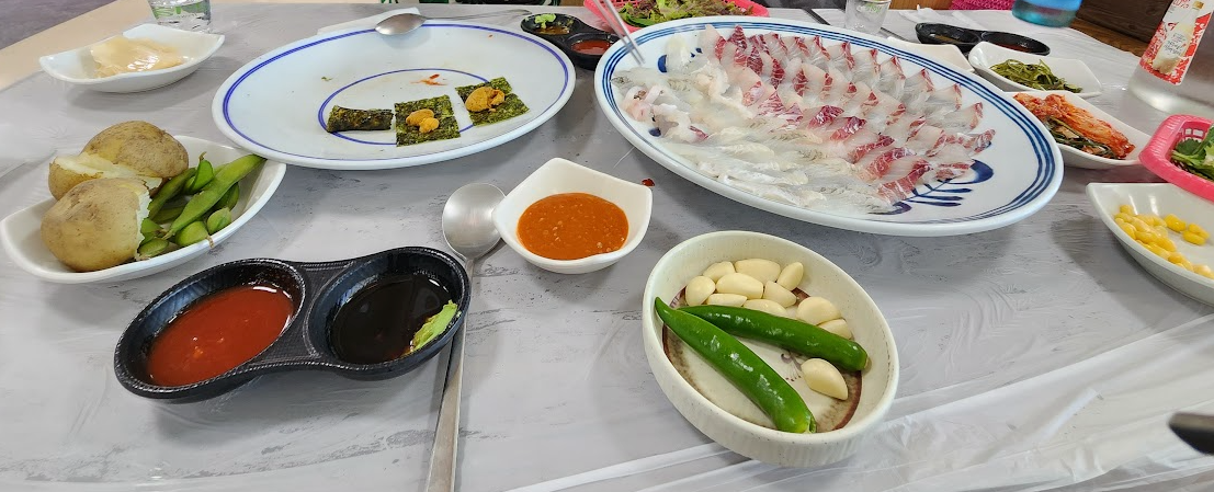 자갈치시장에서 먹은 회와 초장, 간장, 마늘, 고추 등이 놓인 식탁