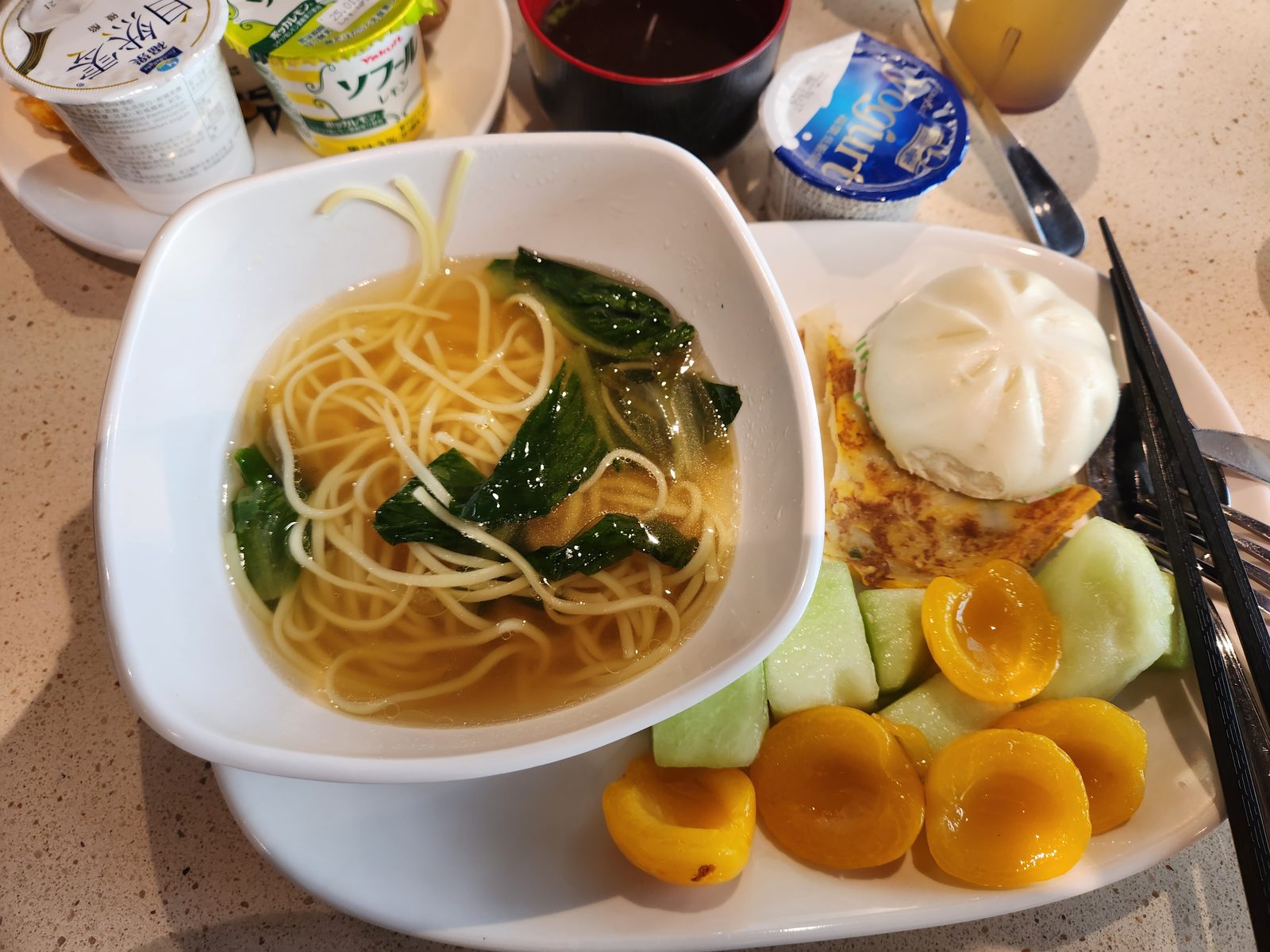 배에서 먹은 면과 찐빵, 과일이 놓인 아침 식탁