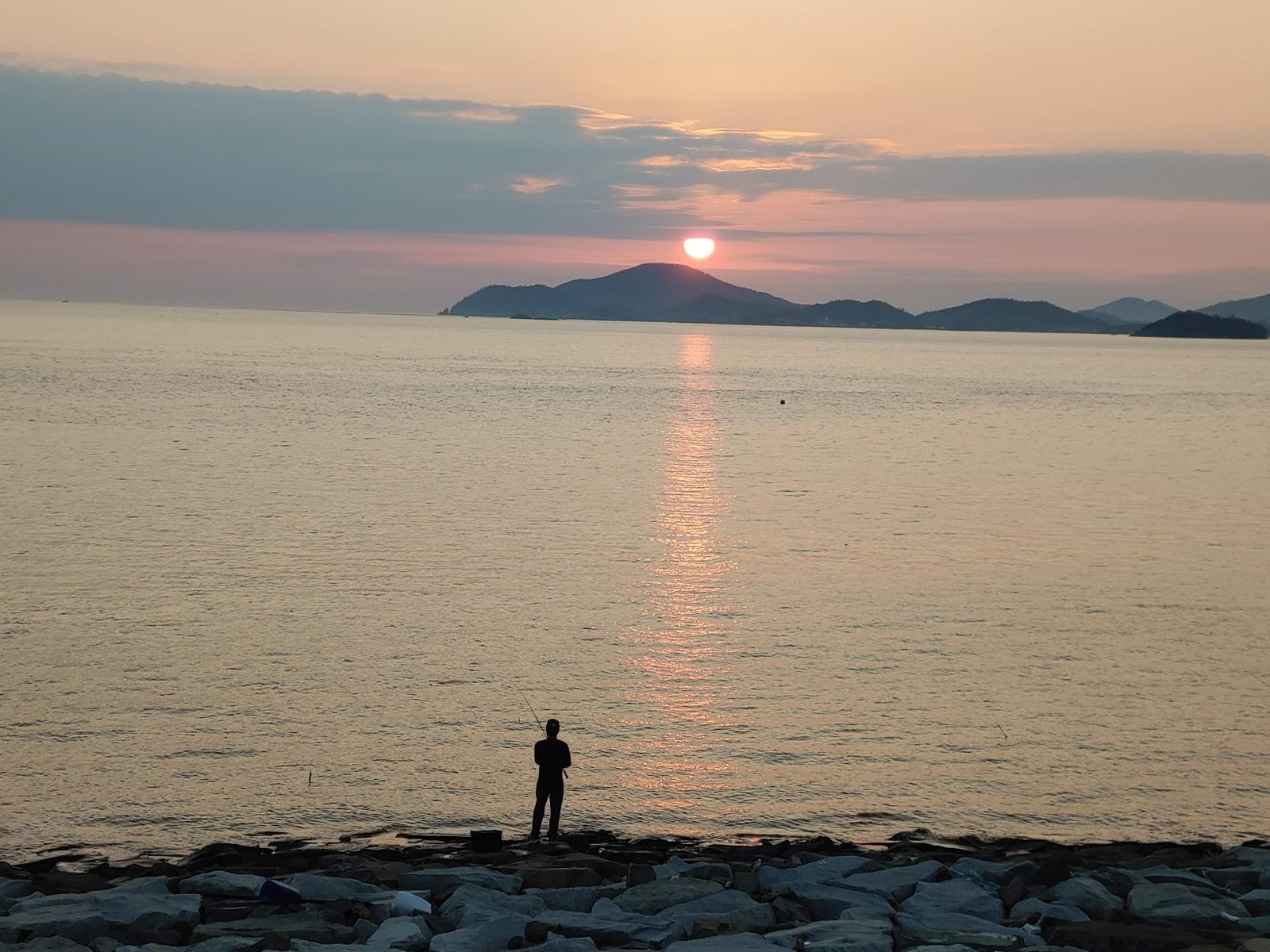 새만금방조제 돌 해안의 사람과 먼 섬 위의 해