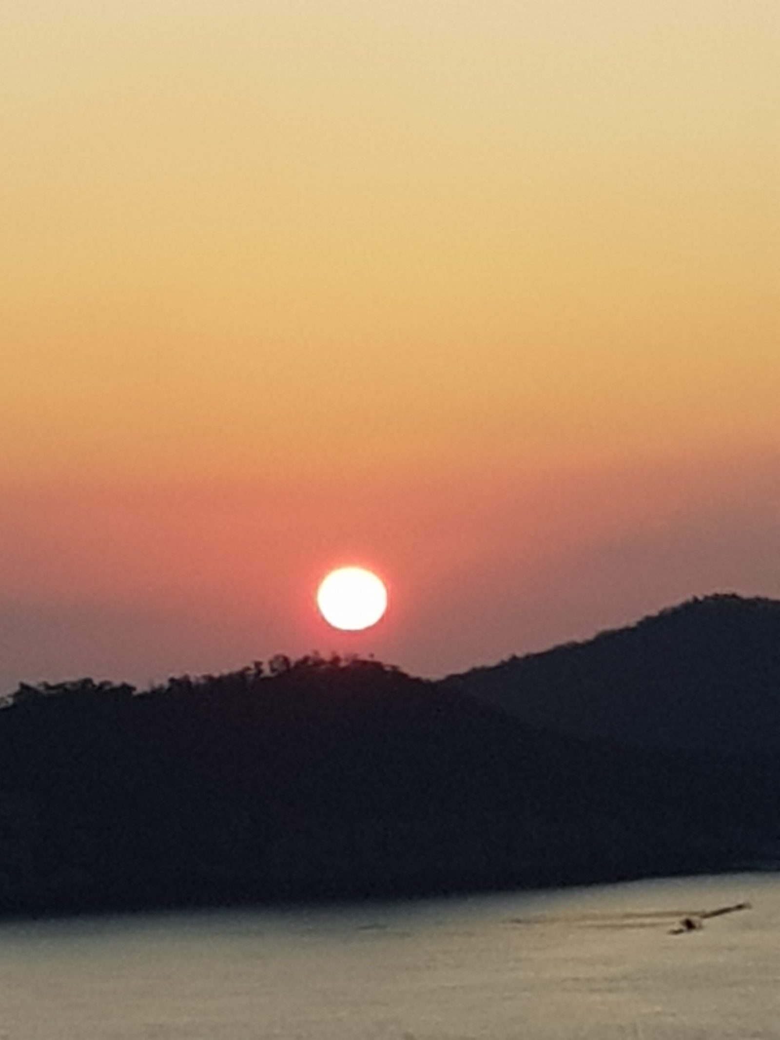 장자도 섬 능선 뒤로 기울어지는 둥근 해