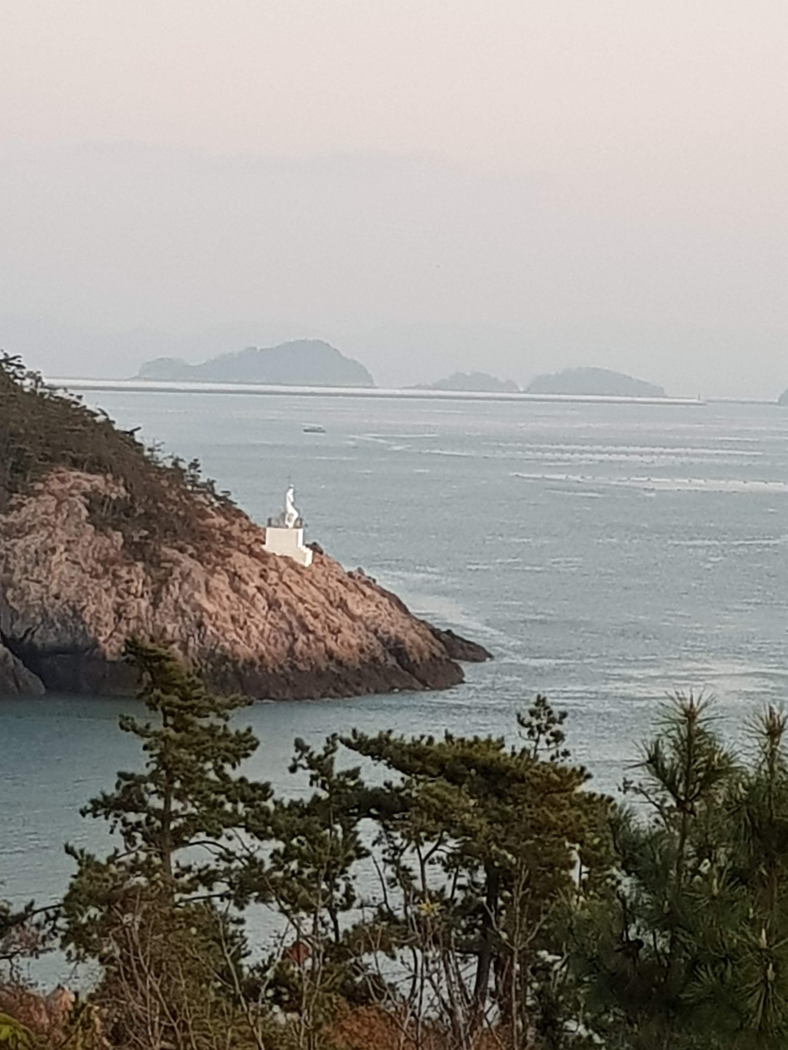 장자도 바위 끝의 흰 등대와 저녁 바다