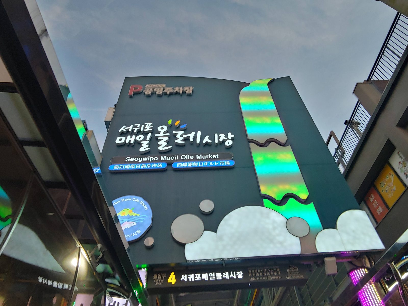 불이 켜진 서귀포매일올레시장 입구 안내 표지